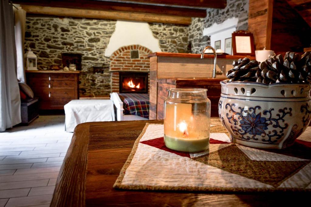 a candle sitting on a table in a room with a fireplace at Chalet in pietra e legno con caminetto in Inverso Pinasca