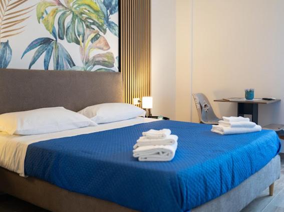 Un dormitorio con una cama azul con toallas. en My Home Catania Rooms, en Catania