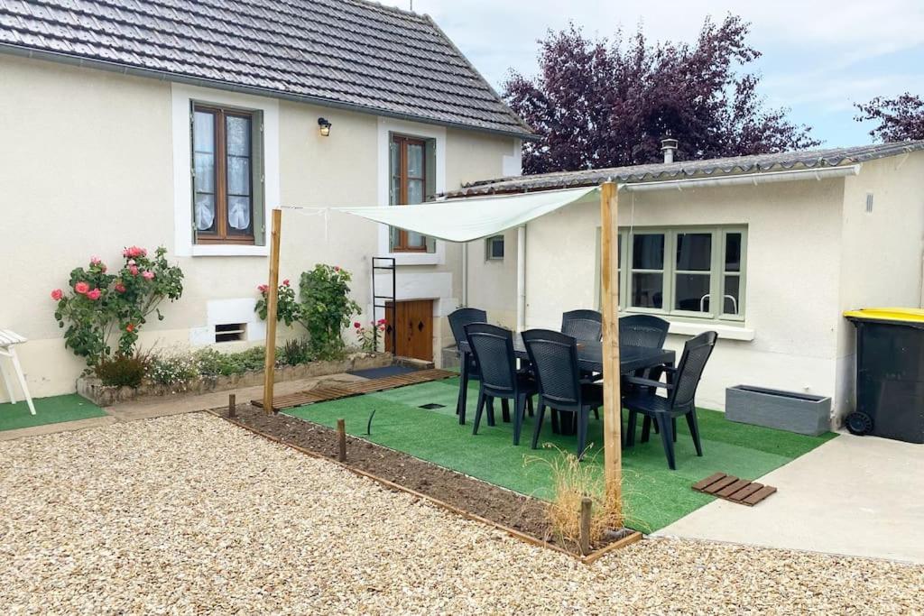 a patio with a table and a white umbrella at La belle vue in Accolay