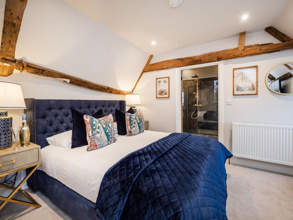 a bedroom with a king sized bed with a blue headboard at The Stag, Oak Room in Salhouse