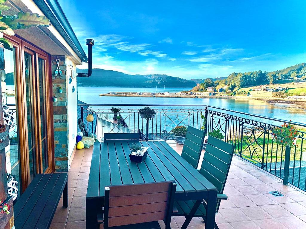 una terraza con un banco y vistas al agua en Ático sobre el Mar Cantábrico, en O Vicedo