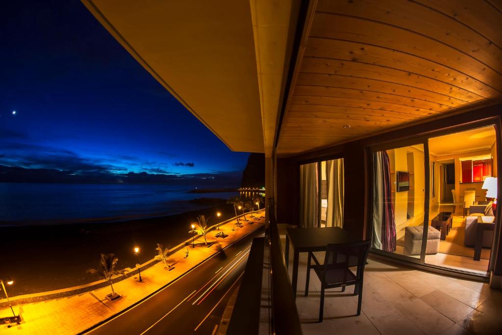 a balcony with a view of the ocean at night at Balcón del Puerto, Ático-Solarium in Tazacorte