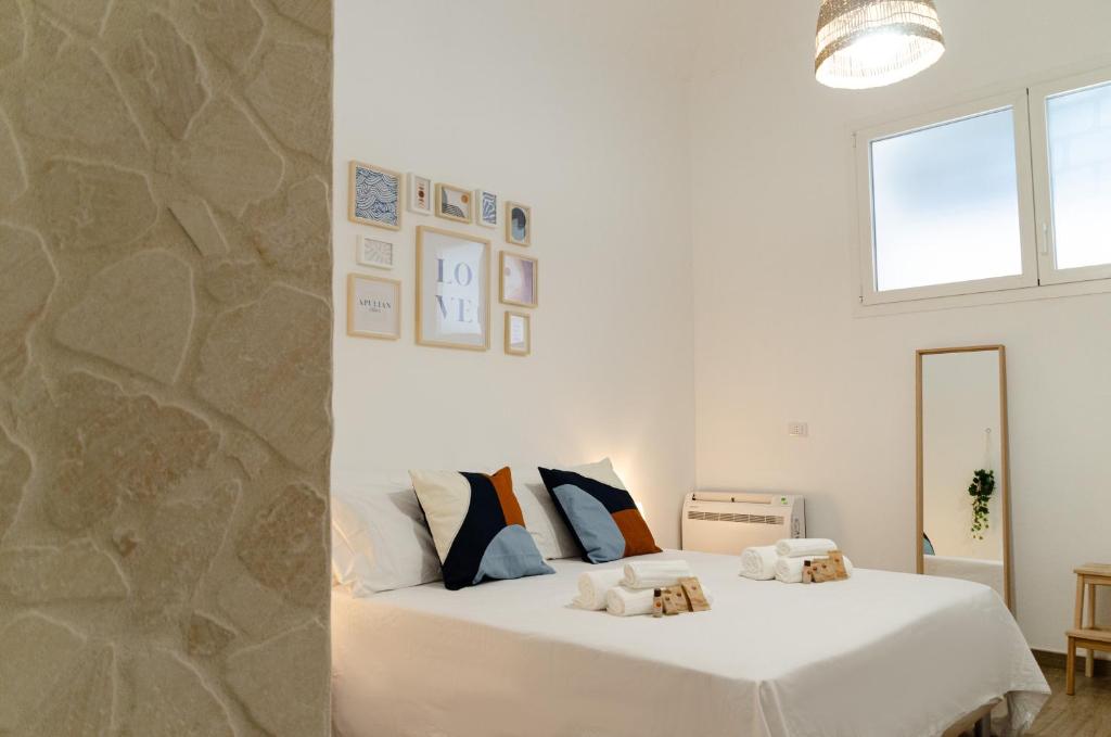 バーリにあるModern Stone Apartment in the Heart of Bariの白いベッドと石の壁が備わるベッドルーム1室