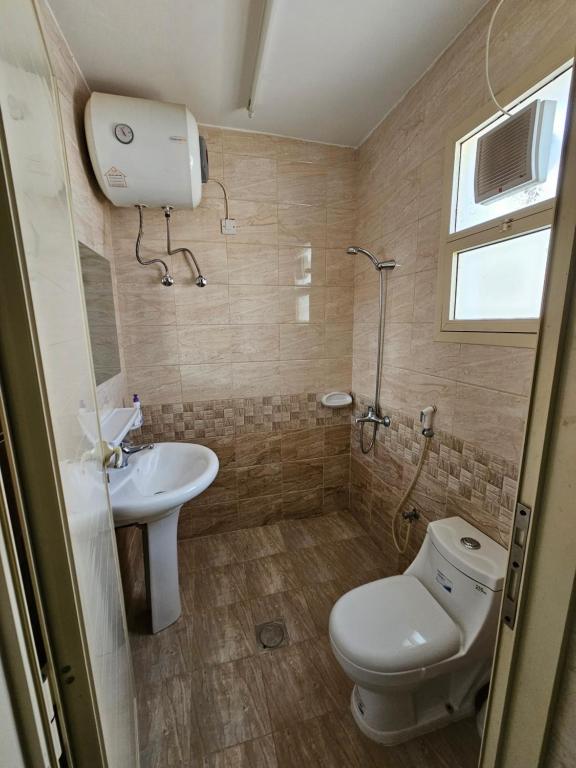 a bathroom with a toilet and a sink at استراحة المسافر in Al Ain