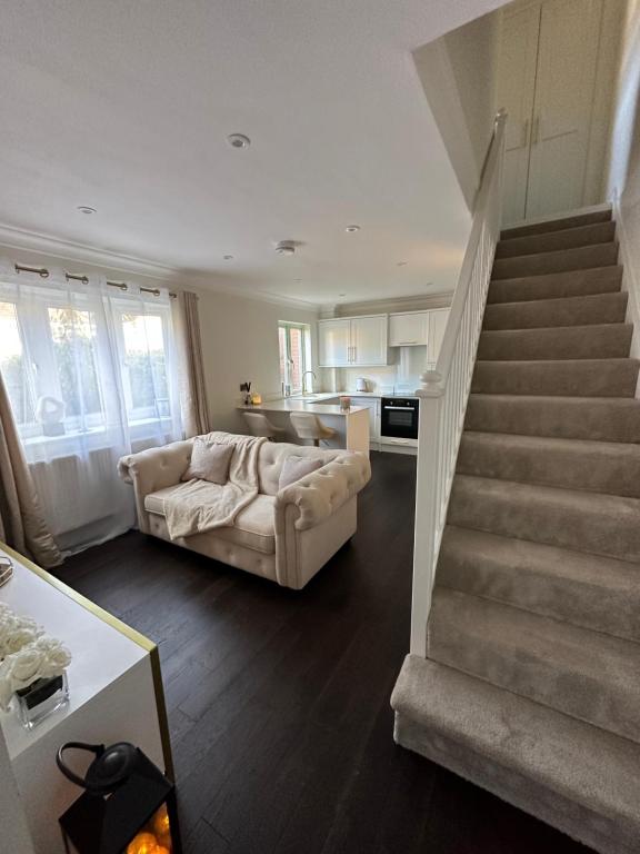een woonkamer met een bank en een trap bij 1 bedroom modern house near hospital with parking in Southampton