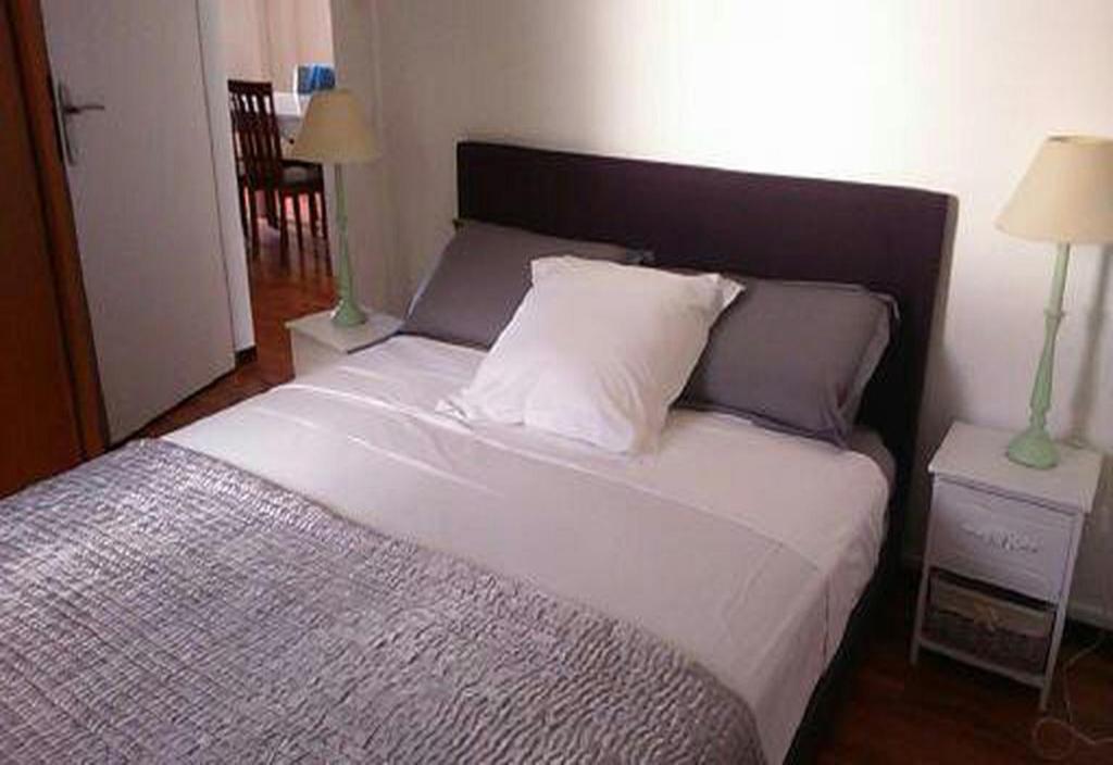 a bedroom with a large bed with two night stands at La Minaude in Saint-Denis