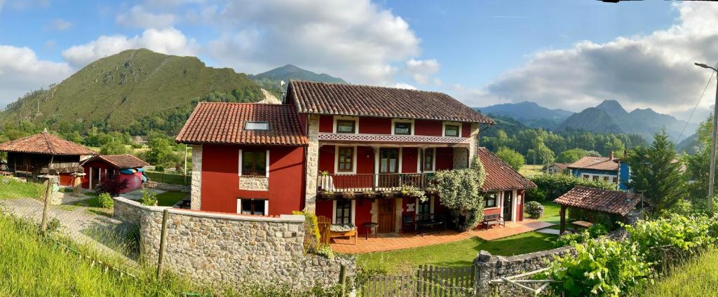 una casa roja con una montaña en el fondo en Casa del Tesoro, en Triongo