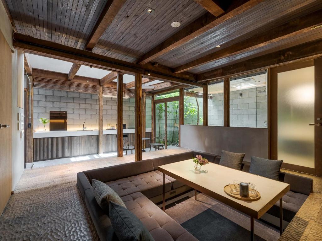uma sala de estar com um sofá e uma mesa em Yuzunoe Machiya House em Quioto
