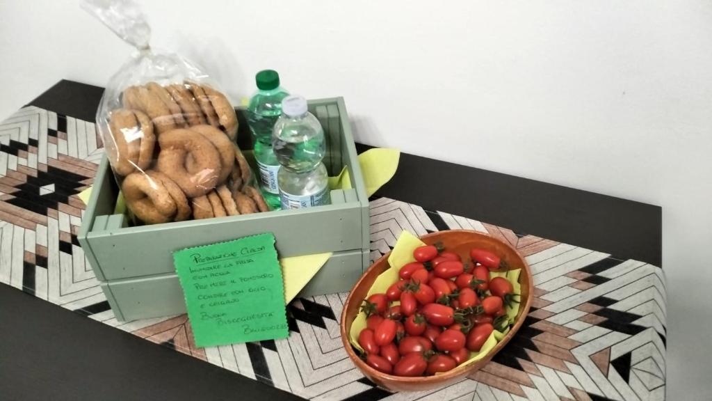 a box of food and a bowl of fruit on a table at Alloggio privato "Ballatoio233" in Bisceglie