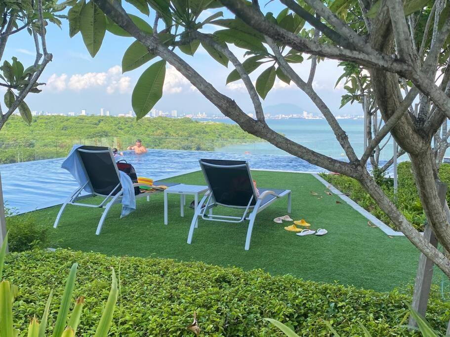 two chairs and a table next to the water at Urban Suites Georgetown, Penang in Jelutong