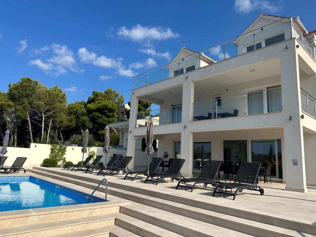 uma casa com piscina e espreguiçadeiras em Villa Lovisa, private pool and amazing sea view em Milna