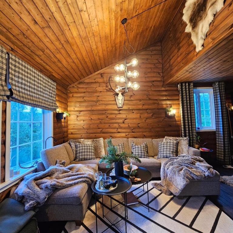 ein Wohnzimmer mit einem Sofa und einer Holzwand in der Unterkunft Bjørnebu- Ski in-ski out in Kvam