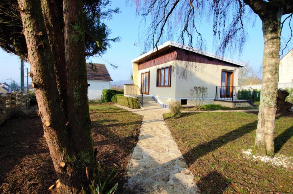 een klein wit huis met een boom ervoor bij Gite du pommerat in Villenauxe-la-Grande