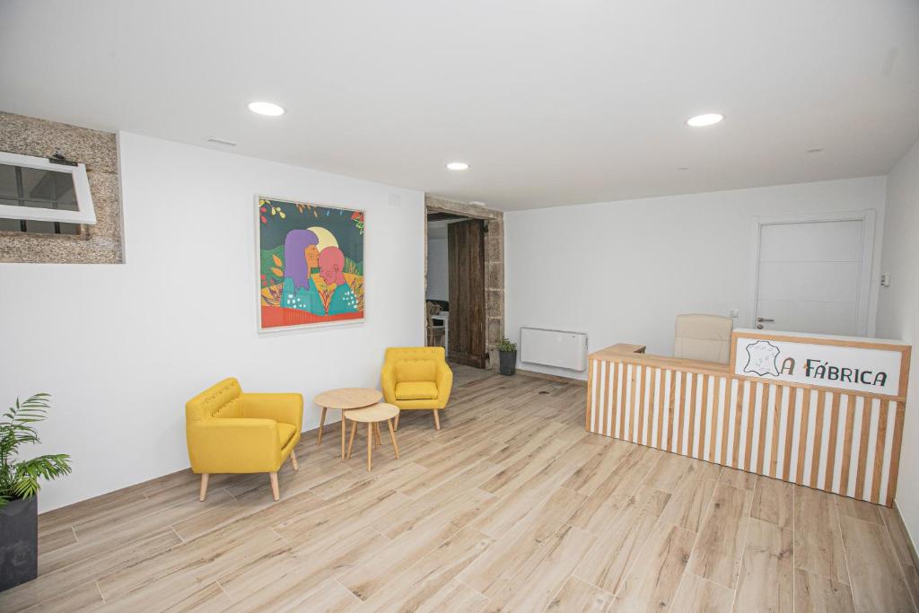 - une salle d'attente avec des chaises jaunes et une table dans l'établissement Albergue A Fabrica, à Saint-Jacques-de-Compostelle