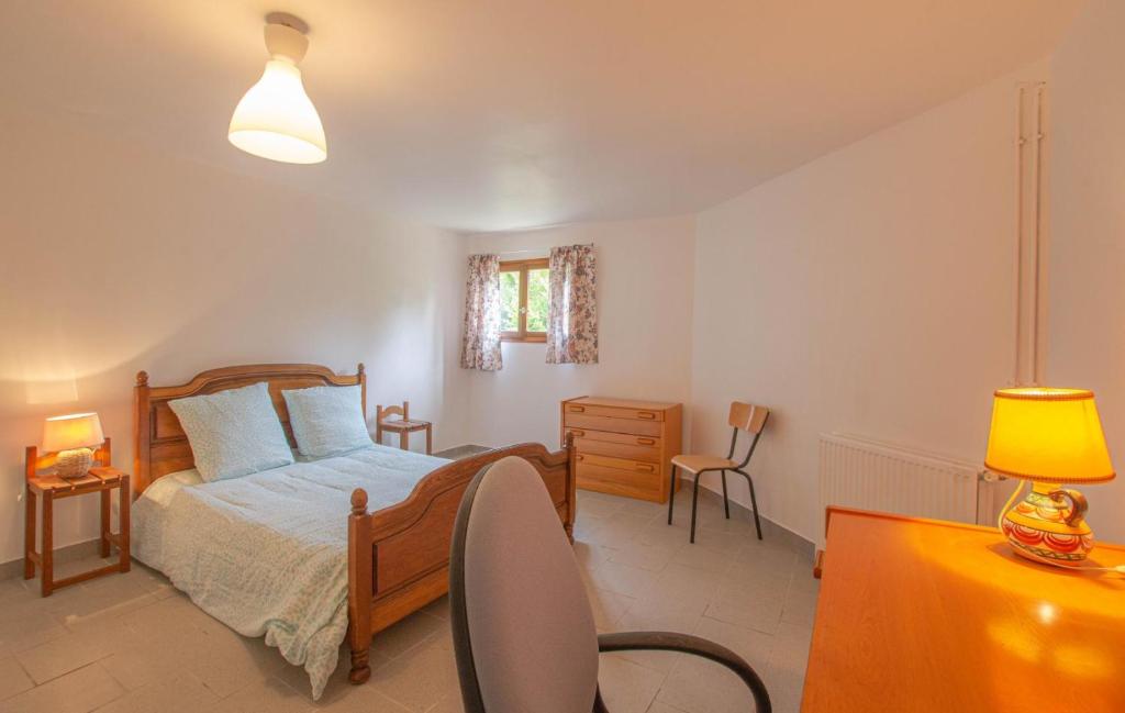 ein Schlafzimmer mit einem Bett und einem Schreibtisch mit einer Lampe in der Unterkunft Le gite de la cea in Saint-Mards-en-Othe