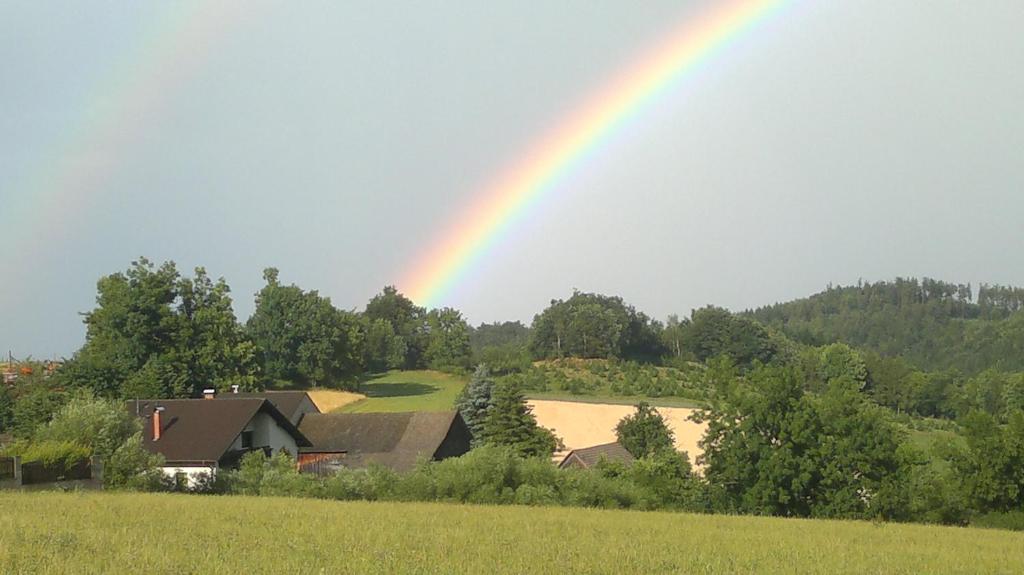 un arc-en-ciel au-dessus d'une maison avec un champ dans l'établissement Hof Sonnegg - Naturpark Jauerling - Wachau, à Maria Laach am Jauerling