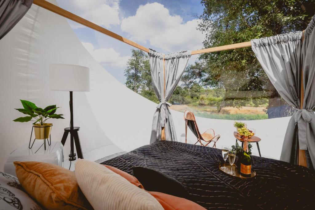 a room with a table and a large window at Golden Glamping nad Narwią in Lubiel Stary