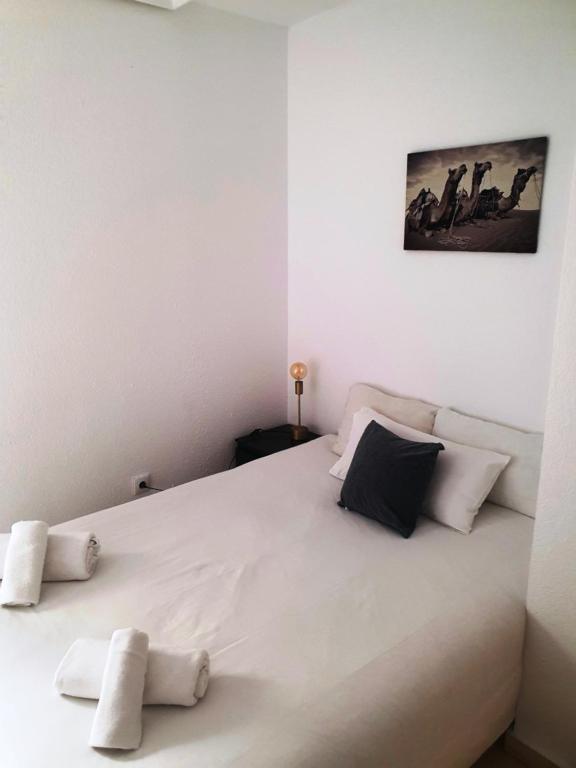 een slaapkamer met een groot wit bed met 2 kussens bij Torneo Life Tranquilo en el centro in Sevilla