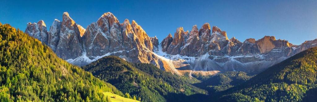 a view of a mountain range with trees at Bilocale in centro ad 1 km dalla pista in Giustino