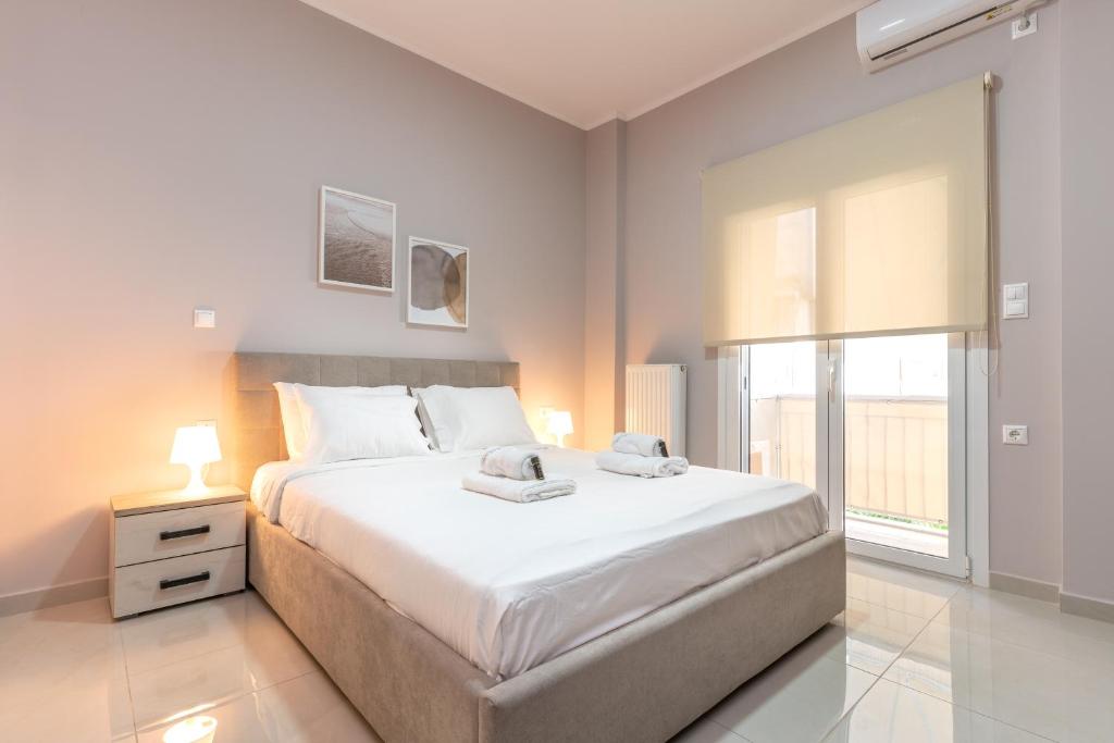 een witte slaapkamer met een groot bed en een raam bij Cosy 2BR Apartment next to Bars & Restaurants in Athene