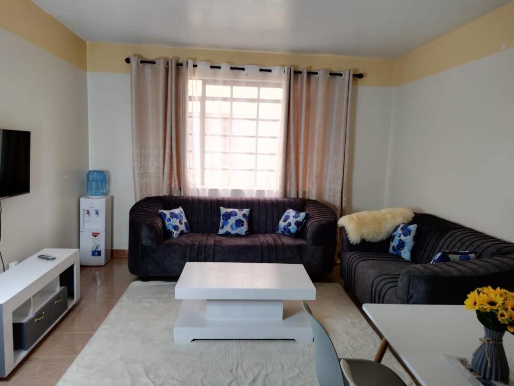 sala de estar con sofá y mesa en Grey Homes, 2 bedroom apartments along mombasa road, near JKIA & SGR Nairobi, en Syokimau