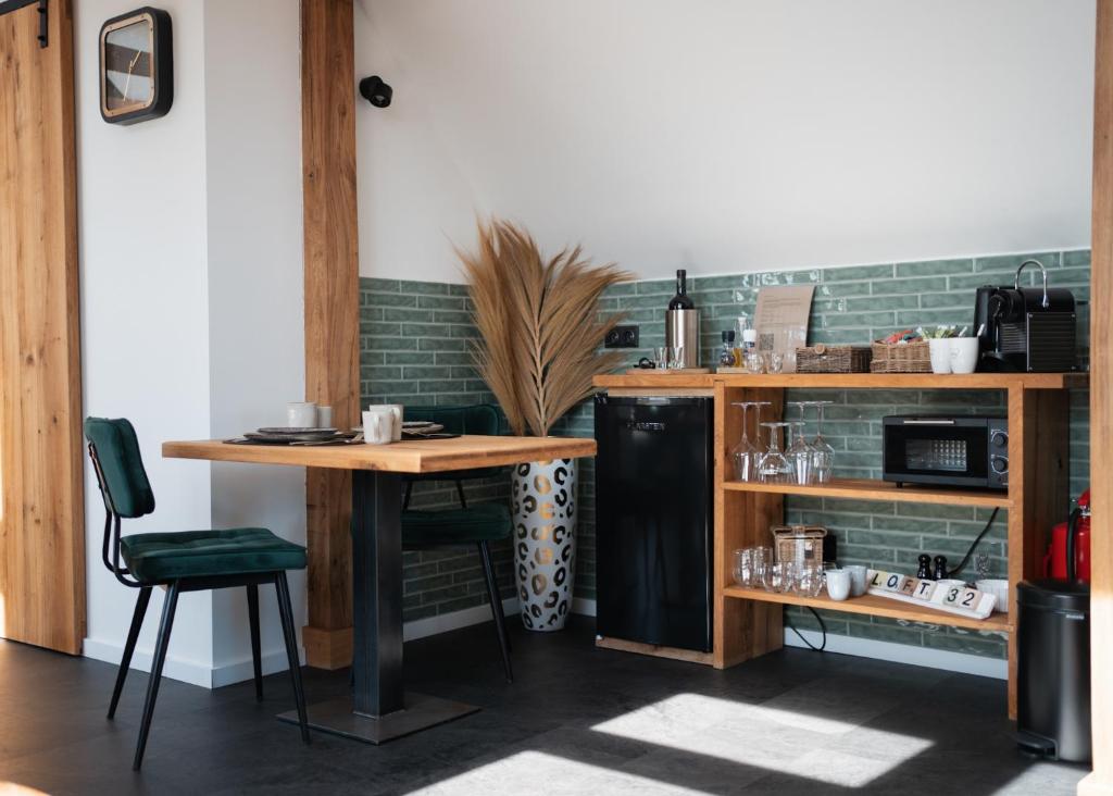 een keuken met een tafel en een zwarte koelkast bij Loft 32 in Winsum