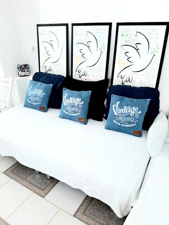 a white bed with three pillows on top of it at Apartments House of Art in Nin