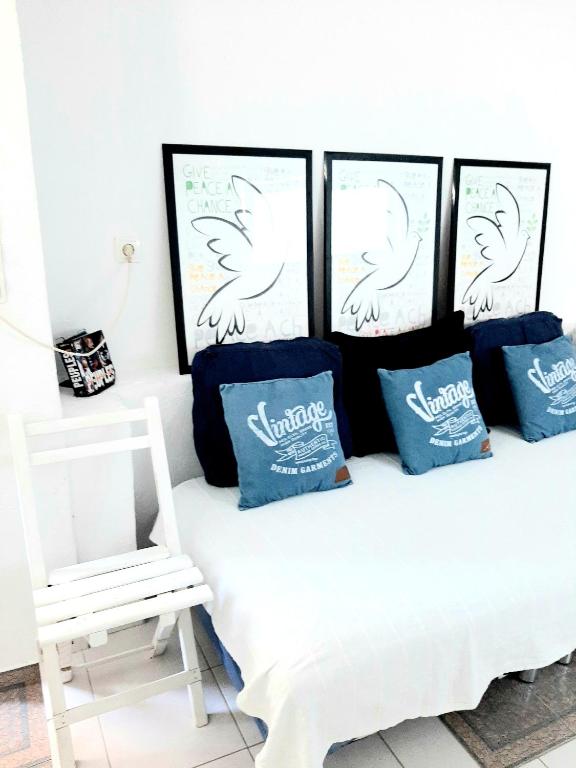 a white bench with three pillows and a white chair at Apartments House of Art in Nin