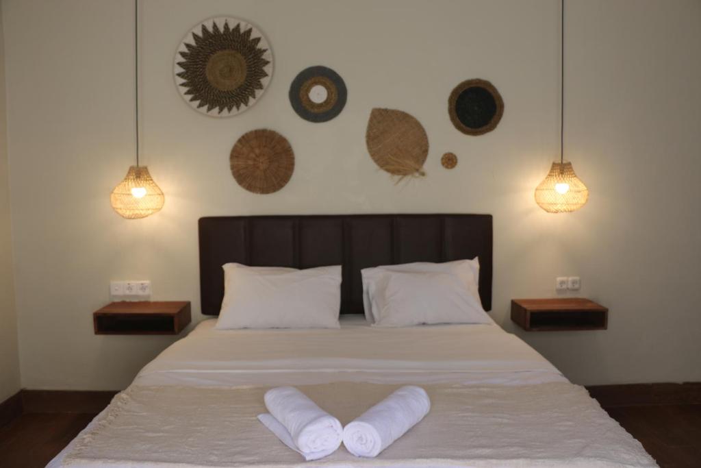 ein Schlafzimmer mit einem Bett mit zwei Handtüchern darauf in der Unterkunft Vogelkopf Resort in Tapokreng
