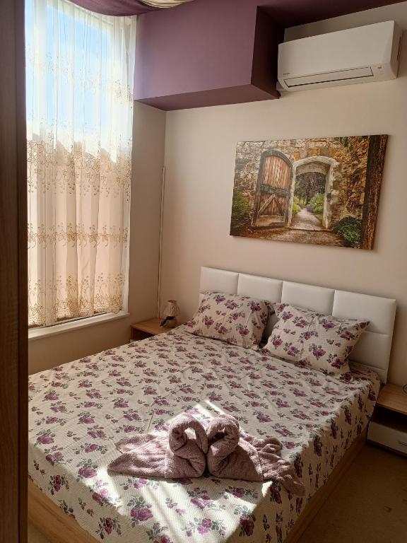a bedroom with a bed with two towels on it at Студио Ариел in Varna City