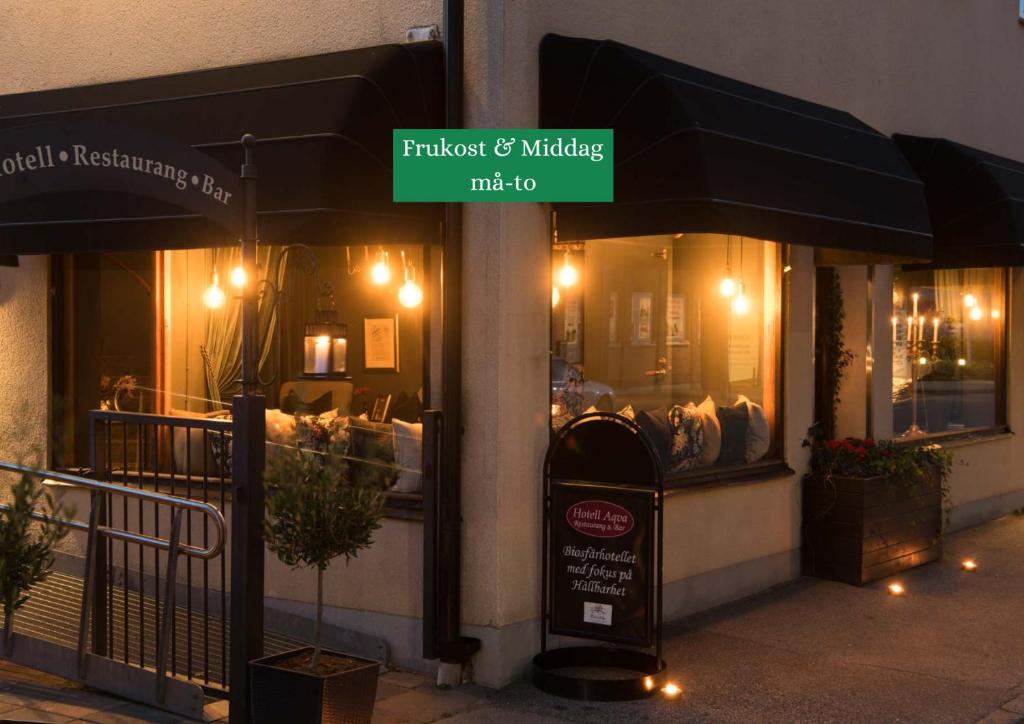 un restaurante con un cartel frente a una tienda en Hotell Aqva Restaurang & Bar Ett Biosfärhotell med fokus på hållbarhet en Mariestad