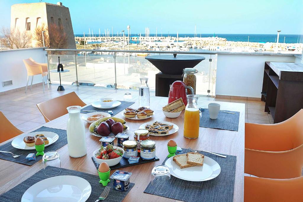 een tafel met eten erop met uitzicht op de oceaan bij THE VIEW B&B, terrace & more in San Foca