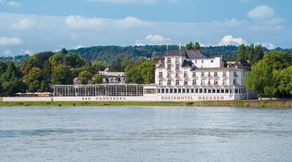 ein großes weißes Gebäude an der Seite eines Flusses in der Unterkunft Rheinhotel Dreesen in Bonn