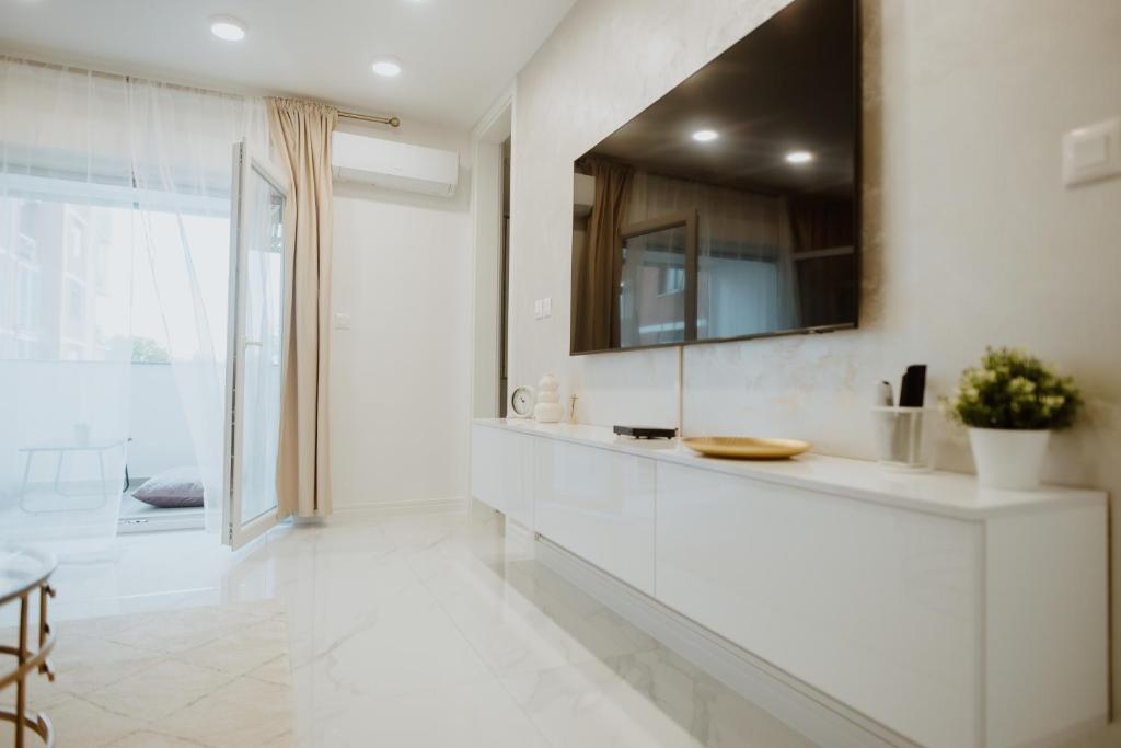 uma casa de banho branca com um lavatório e um espelho em Apartman 007 em Vukovar