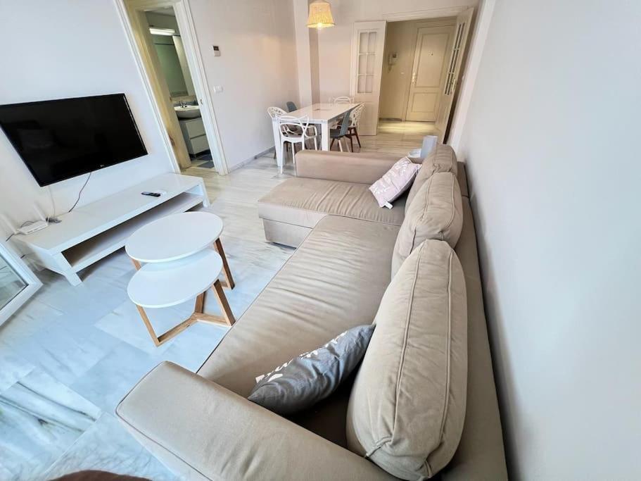 a living room with a couch and a tv at PUSHE Playa Granada Beach & Golf 17 in Motril