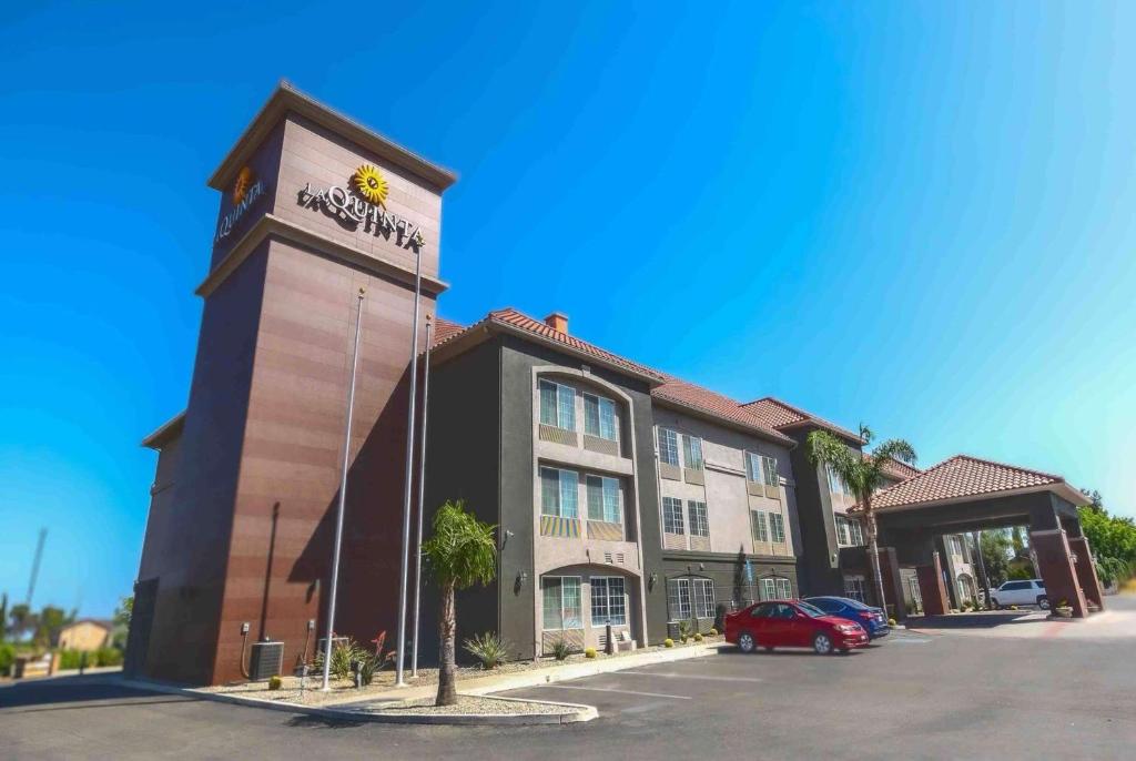 a hotel with a sign on the side of a building at La Quinta by Wyndham Fowler in Fowler