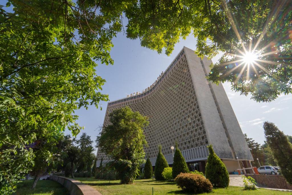 um edifício com o sol no céu em Hotel Uzbekistan em Tashkent