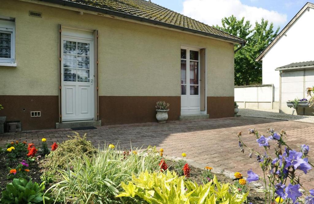 una casa con un jardín de flores delante de ella en Le claujovin en Méry-sur-Seine