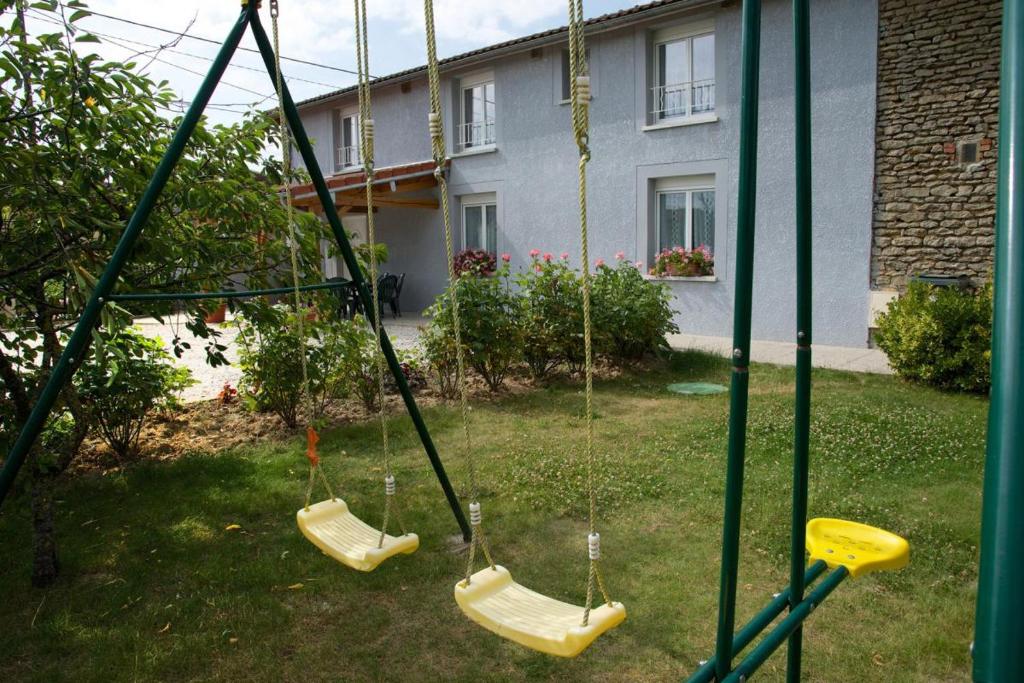eine Schaukel in einem Hof mit einem Haus in der Unterkunft Le saint laurent in Morvilliers