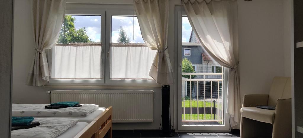 a bedroom with two beds and a large window at Pension Ramser in Lindhorst