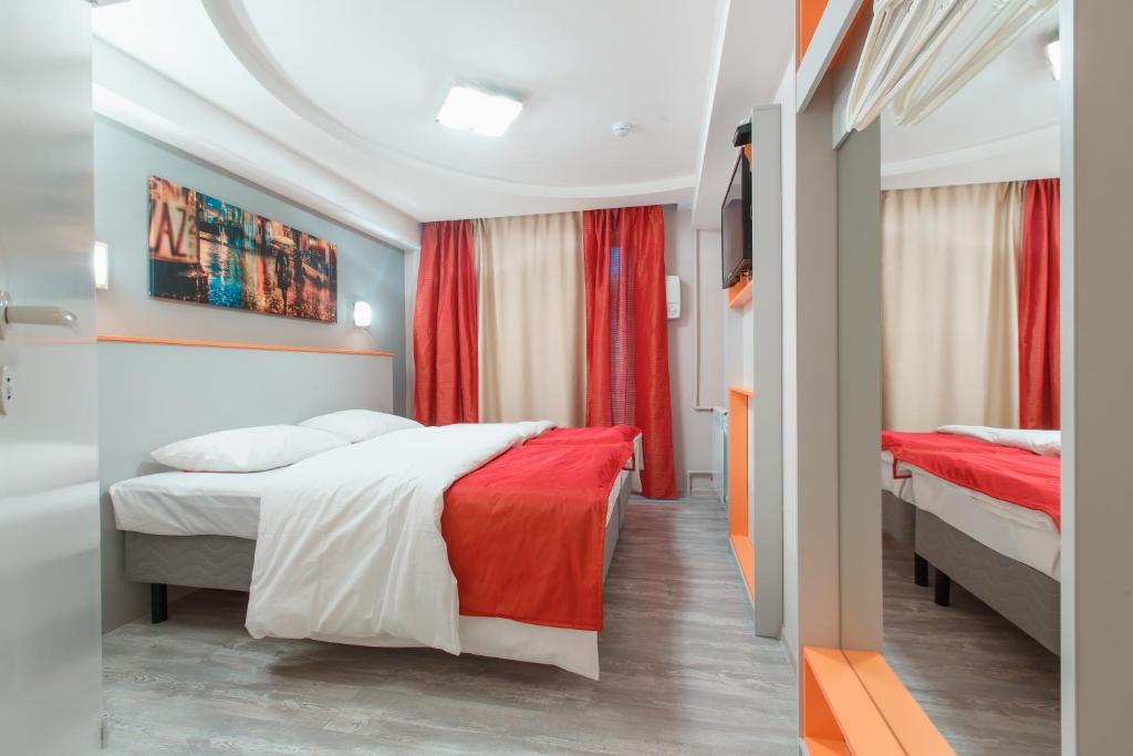 a hotel room with two beds and red curtains at Art-hotel Zontik in Saint Petersburg