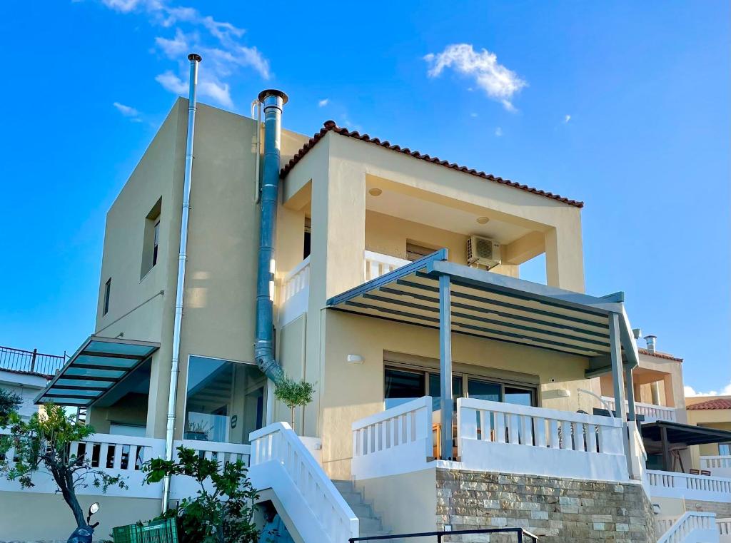 a building with a blue sky in the background at Villa Cook with pool and terraces with sea views in Dhaskalianá