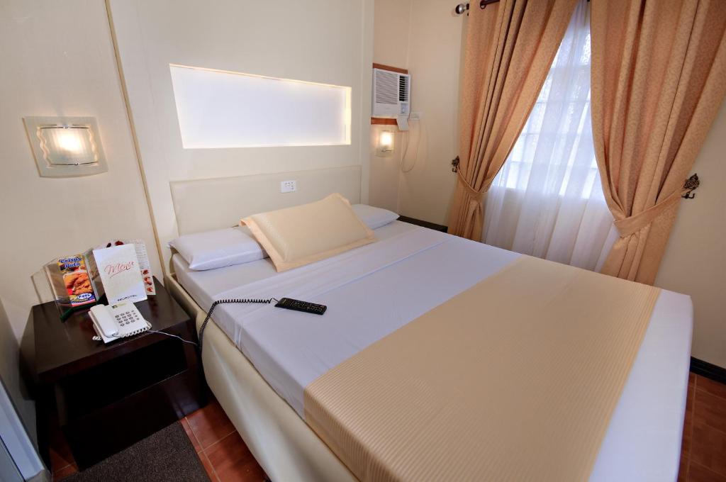 Postel nebo postele na pokoji v ubytování Eurotel Makati