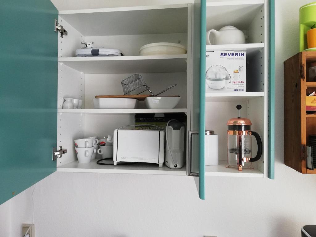 a cupboard with dishes and other kitchen items in it at Centrum Aarhus in Aarhus