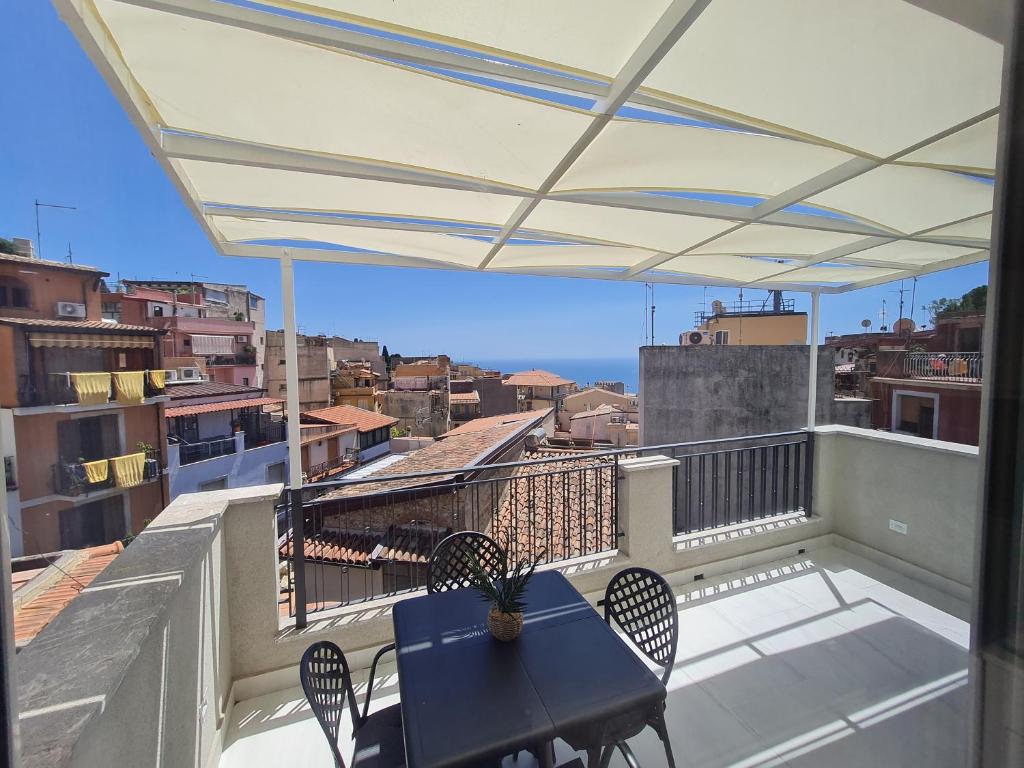 a patio with a table and chairs on a balcony at EPONIMI ROOMs in Taormina