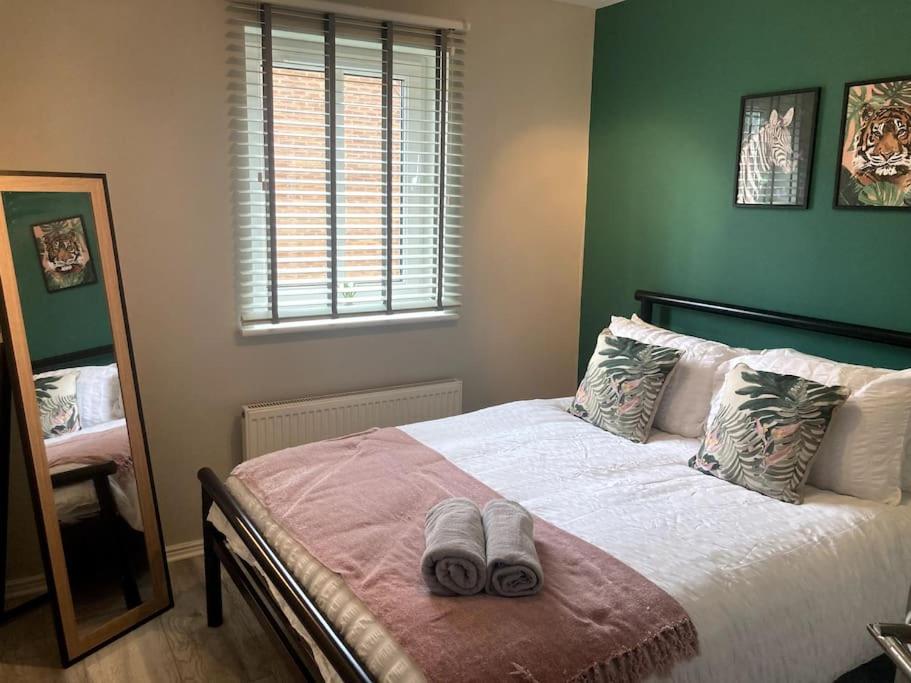 a bedroom with a bed with two slippers on it at Modern 3 bed home, Chesterfield in Chesterfield