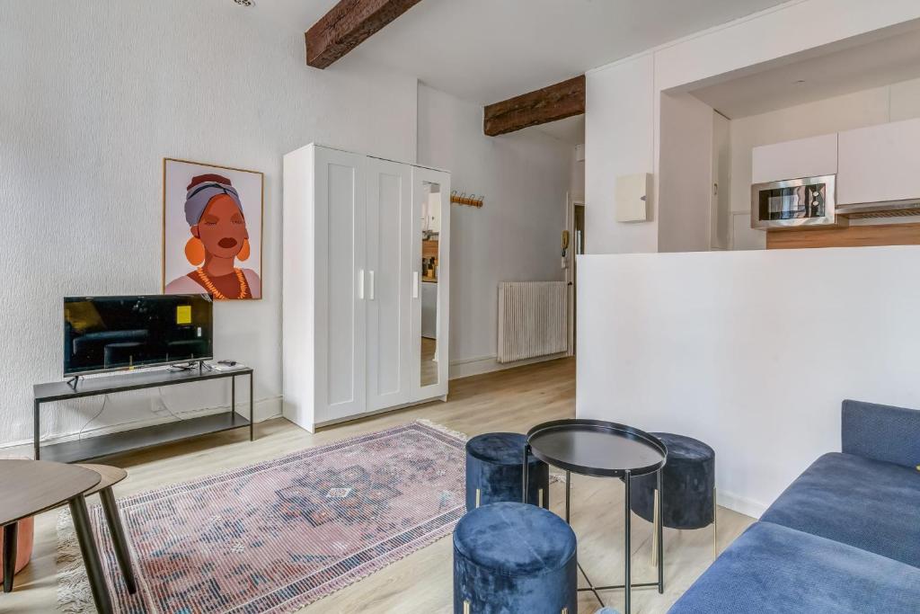 Charming studio in the centre of Toulouse - Welkeys في تولوز: غرفة معيشة مع أريكة زرقاء وطاولة