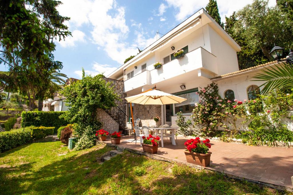 a house with a patio and an umbrella at Villa Orchidea by PortofinoHomes in Santa Margherita Ligure