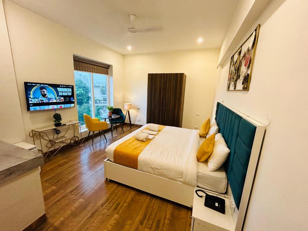 een slaapkamer met een bed, een tafel en een televisie bij Amahi Inn in Gurgaon
