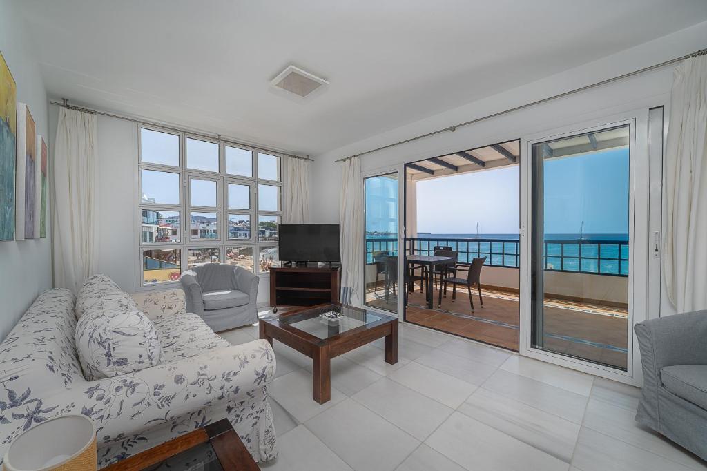 sala de estar con sofá y vistas al océano en Apartamento 1 linea centro Playa Blanca, en Playa Blanca
